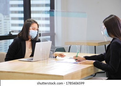 Manager From HR Department Wearing Facial Mask Is Interviewing New Applicant Who Is Signing Her Contract Through The Partition For Social Distancing And New Normal Policy