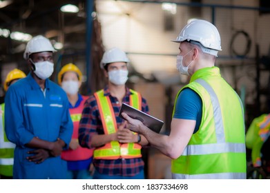 Manager Or Leader Are Training And Assignmenting A Job For Team Of Technicians, Supervisor, Foreman And Engineers In The Morning Meeting Before Work In Which Everyone Wear Masks To Prevent Coronavirus