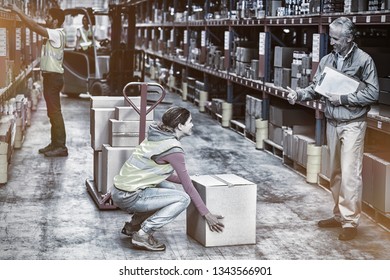 Manager looking a worker with thumbs up in a warehouse