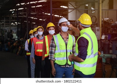 Manager Monitoring Supervisor Or Engineer And Technician Leader Screening Or Checking Or Inspect Or Measure Body Temperature Meter Before Working At Factory As Covid New Normal Concept