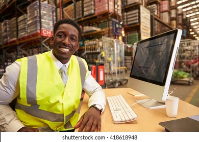 Manager in the on-site office of a warehouse looks to camera