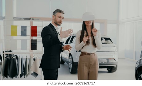 Manager providing innovative method for selecting auto. Potential client using VR headset while choosing vehicle. Learning information about car model with high-tech. Modern customer interaction.