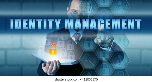 Manager pushing IDENTITY MANAGEMENT on a virtual interactive touch screen interface. Information technology security concept for managing the identification of individuals, hardware and application.