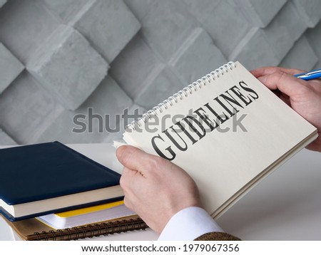 Manager reads Guidelines and holds blue pen.