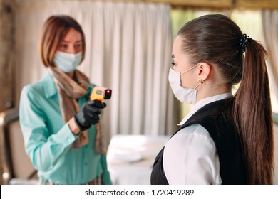 The Manager Of A Restaurant Or Hotel Checks The Body Temperature Of The Staff With A Thermal Imaging Device