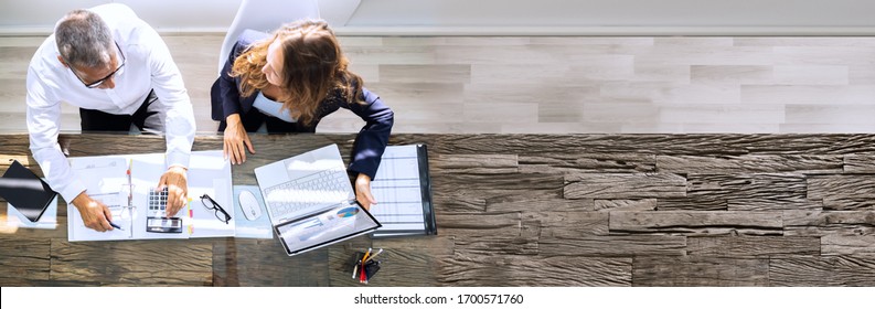 Manager And Senior Accountant Using Laptop In Office