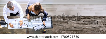 Manager And Senior Accountant Using Laptop In Office