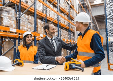 Manager shaking hands with a worker in a logistics warehouse, finalizing a successful business deal