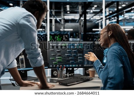 Manager supervising technician programming in server farm housing infrastructure storing datasets. Team leader overseeing IT expert coding, repairing data center racks doing computational operations