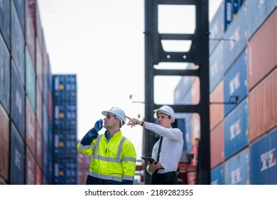 Manager and Supervisor dock cargo checking and control loading Containers box at Container yard warehouse,Unity and teamwork concept.