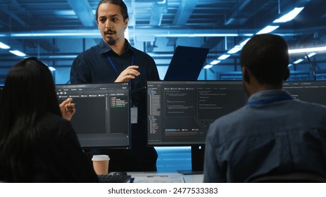 Manager and IT support specialists working together, supervising server rows in computer network security data center. Supervisor and multiethnic employees overseeing supercomputers - Powered by Shutterstock