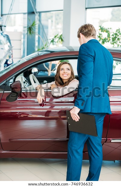 Manager\
talking with a customer after test-driving a car\
