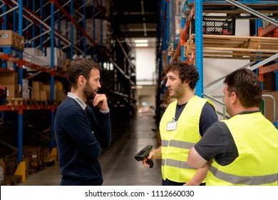 Manager Talking With Employees In Warehouse