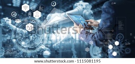 
Manager Technical Industrial Engineer working and control robotics with monitoring system software and icon industry network connection on tablet. AI, Artificial Intelligence, Automation robot arm. 