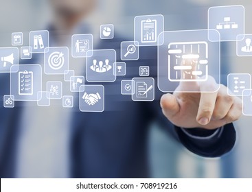 Manager touching AR virtual screen interface button about project management with icons of scheduling, budgeting, communication - Shutterstock ID 708919216