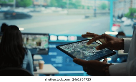 Manager tracking a delivery car by using satellite map for navigating around the city, monitoring orders via surveillance footage and CCTV system. Locating coordinates for shipping route. Camera B. - Powered by Shutterstock