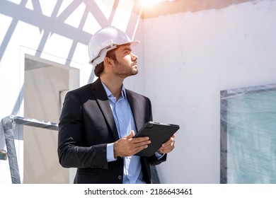 Manager Using Tablet Checking The Construction Progress Of The Housing Project.