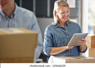 Manager Using Tablet Computer In Distribution Warehouse