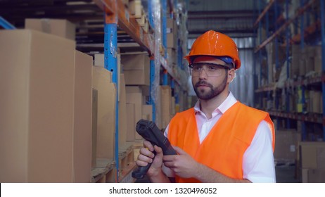 manager using wireless barcode scanner scanning labels on boxes before delivery in logistic center. Handsome professional worker wearing uniform white shirt high visibility orange hard hat and vest. - Powered by Shutterstock - Get 15% off with code: PIKWIZARD15