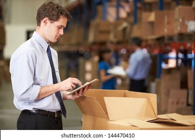 Manager In Warehouse Checking Boxes Using Digital Tablet