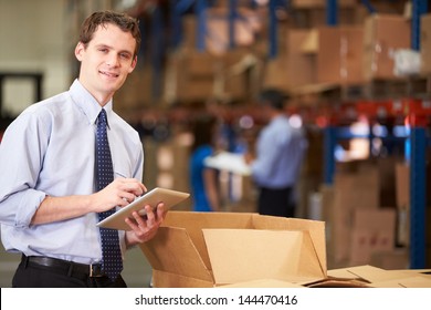 Manager In Warehouse Checking Boxes Using Digital Tablet