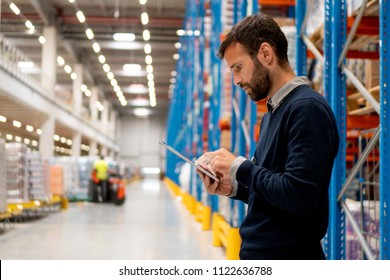 Manager in warehouse holding digital tablet - Shutterstock ID 1122636788