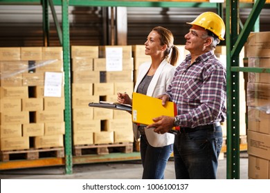 Manager and warehouse worker checking list and inventory on the shelf in storehouse.