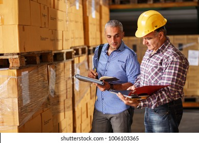 Manager and warehouse worker checking list and inventory on the shelf in storehouse.