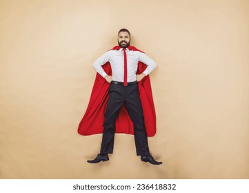 Manager Wearing A Red Superman Cloak. Studio Shot On A Beige Background.