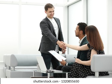 Manager Welcomes Customers In The Lobby Of The Bank.