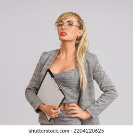 Manager Woman In A Gray Suit And Glasses With An Empty Tablet In Her Hand On A White Background With Copy Space, Half-length Portrait, Mockup