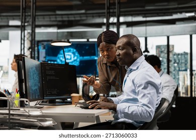 Manager and IT worker testing AI machine learning algorithms at work. Team leader supervising engineer scaling productivity with artificial intelligence large language model technology