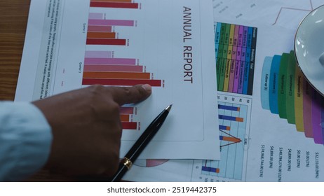 manager working on laptop while looking at data analysis. Leader compare financial statistic graph while making decision at meeting table with document scatter around. Convocation. of business people 