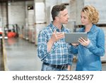 managers are looking a tablet in a warehouse