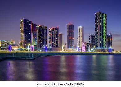 Manama, Bahrain - February 16, 2021: Beautiful view of high rise buildings in Seef district illuminated at night.