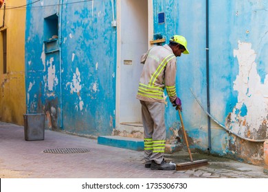 Manama, Bahrain - May 18, 2020: A Street Cleaner At Work In Muharraq Street, Bahrain. Many Of Asian Workers Are Employed In GCC Cleaning Companies.