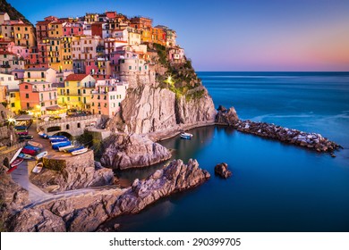 Manarola, Liguria, Italy. The wonderful Manarola village as you can see it from the mountain above. Quiet sky and peaceful sea, during sunset.