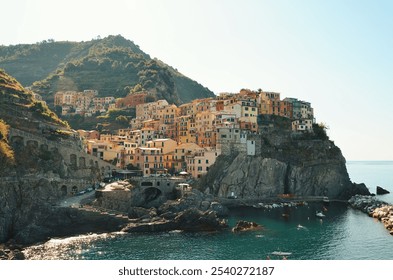 Manarola, a vibrant village in Cinque Terre, Italy, with colorful cliffside houses overlooking the Ligurian Sea, surrounded by lush hills and rocky coastline, is a popular UNESCO World Heritage site. - Powered by Shutterstock