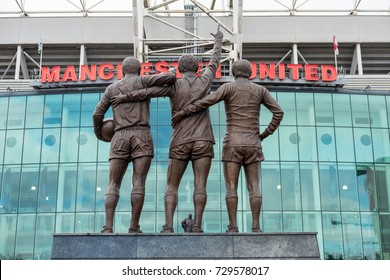 Manchester, England - 5 October 2017 : Old Trafford stadium the home of Manchester United with trio statue of George Best, Denis Law, and Sir Bobby Charlton