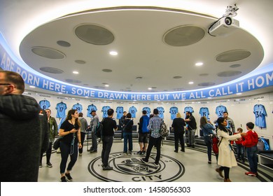 MANCHESTER - ENGLAND, MAY 16, 2019 : A Group Tour With Player's Jerseys Hung In Front Of Lockers In The Changing Room At Etihad Stadium; The Home Ground Of Manchester City Football Club.