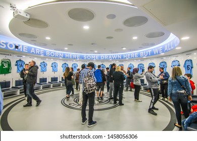 MANCHESTER - ENGLAND, MAY 16, 2019 : A Group Tour With Player's Jerseys Hung In Front Of Lockers In The Changing Room At Etihad Stadium; The Home Ground Of Manchester City Football Club.