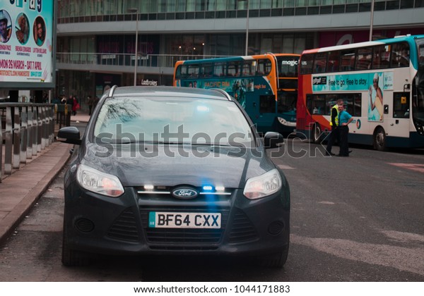Manchester, Greater\
Manchester / United Kingdom - March 11th 2018: Unmarked police car\
arrives at Manchester Piccadilly railway station while buses wait\
in the background.