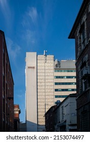 Manchester, Lancashire, England - April 20, 2022. White Tall Building That Stands Out From Others That Are In The Shade. Vertical Photo.