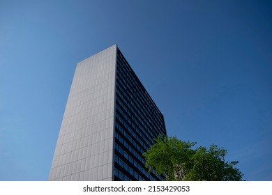 Manchester, Lancashire, England - April 20, 2022. Tall Building And Tree Against A Blue Sky In Manchester City Centre.