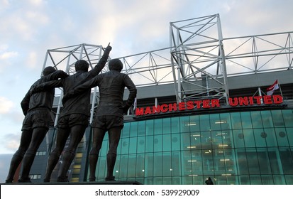 MANCHESTER - MARCH 2, 2013: The United Trinity refers to the Manchester United trio of George Best, Denis Law, and Sir Bobby Charlton at the front of Old Trafford Stadium in Manchester, England, UK