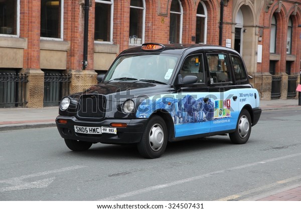 MANCHESTER, UK - APRIL 22, 2013: Taxi cab drives\
in Manchester, UK. There are 242,200 taxi and private hire licences\
in England (as of March\
2015).