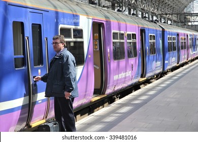 MANCHESTER, UK - APRIL 23, 2013: Worker Boards Northern Rail Train In Manchester, UK. NR Is Part Of Serco-Abellio Joint Venture. NR Has Fleet Of 313 Trains And Calls At 529 Stations.