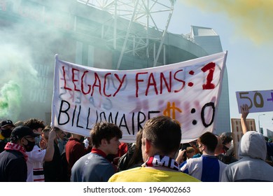 Manchester, UK. April 24, 2021. Protest Against Glazer At Old Trafford Football Ground. Supporter Holding Banner With Text Legacy Fans 1, Billionaire 0 With Manchester United Stadium In Background.