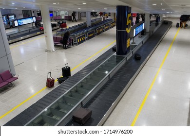 Manchester, UK - February 19 2020: UK Airport Baggage Reclaim Area. Manchester Airport Terminal Arrivals Empty Luggage Carousel With Parked Trolleys In Background.