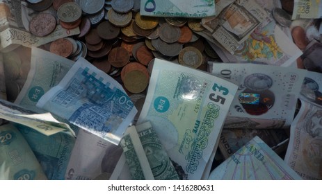 Manchester / UK - June 03 2019: Closeup Of Bills And Coins From Different Countries In A Donation Box At Manchester Airport. 